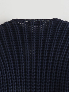 Macro detail of dark navy fish scale knit texture on this chunky cardigan sweater