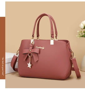 Pink PU leather handbag detail with elegant bow, metal star pendant and gold hardware