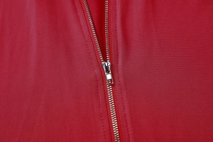 Close-up of a silver metal zipper on premium red knit fabric showing texture and detail
