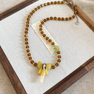 Detail of forest fairy beaded necklace with green leaf charm and brown crystal beads