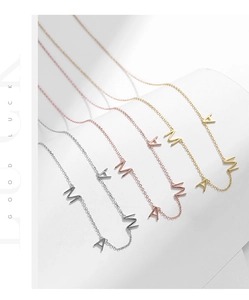 Vue détaillée des pendentifs MAMA en argent, or rose et plaqué or classique