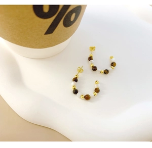 Detail of C-shaped S925 silver stud earrings with tiger eye stone and gold metallic beads