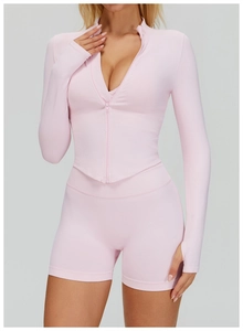 Détail de la manche de veste de yoga rose avec passe-pouce et tissu athlétique stretch