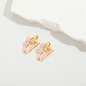 Detailed macro of pink enamel Evil Eye V-shaped earrings with gold plating and zircons