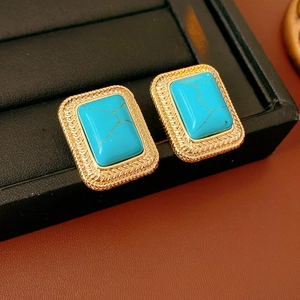 Primo piano dei dettagli degli orecchini dorati vintage con turchese blu rettangolare