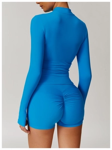 Detail of blue high-waist ruched fitness shorts and long sleeve zip-up athletic jacket