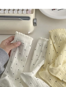 Détail de chaussettes à dentelle de style japonais avec pois et bords ondulés