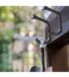 Detailed close-up of industrial cast iron hooks with vintage texture on wood beam