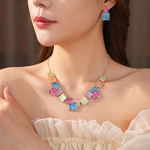 Close-up of model wearing geometric square enamel pendant necklace and earring jewelry set
