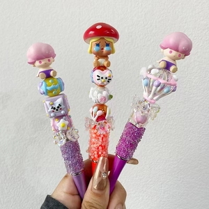 Detail of handcrafted acrylic bead pens featuring colorful glitter and cartoon character toppers