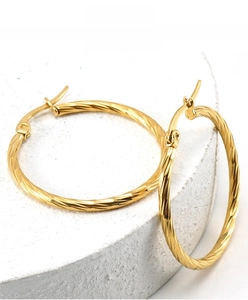 Detail of 18K gold-plated stainless steel hoop earrings with spiral carved texture