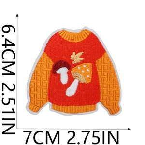 Detail view of embroidered sweater patch with maple leaf and mushroom showing 7cm x 6.4cm dimensions