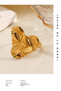 Macro shot of irregular wavy heart-shaped gold ring with liquid metal texture finish