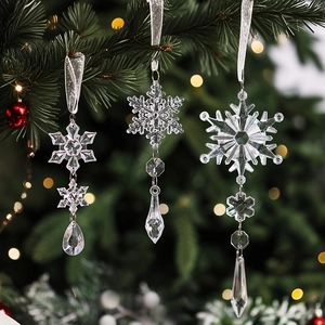 Detailed view of clear acrylic snowflake ornaments hanging on a festive Christmas tree branch