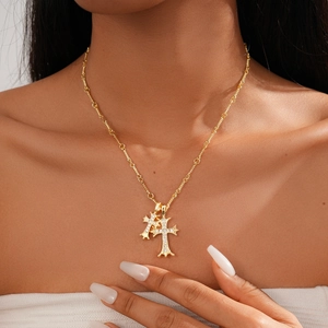 Close-up of 18k gold plated double cross pendant necklace with zircon on a model