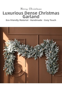 Close-up of a luxury Christmas garland with artificial snow and warm LED lights on door