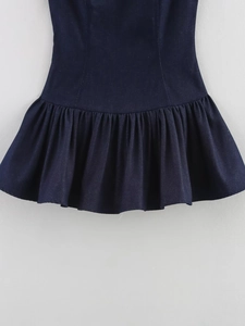 Détail d'une mini robe sans manches bleu foncé avec ourlet plissé et texture denim