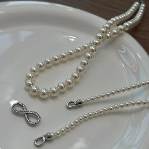 Close-up of S925 silver clasp on elegant layered pearl necklace in a ceramic dish