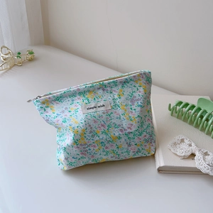 Detail of floral makeup bag featuring a simple wish label and smooth silver zipper closure