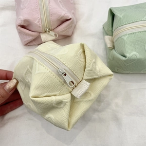 Détail des trousses de maquillage en cuir PU gaufré de cœurs aux couleurs pastel douces