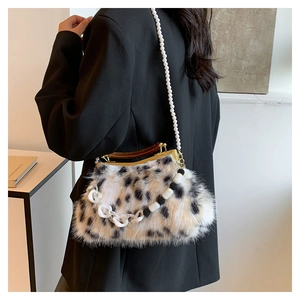 Détail du sac en fausse fourrure avec bandoulière perle et poignée en bois sur costume noir