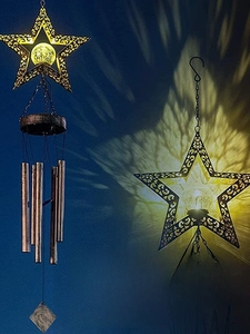 Close-up of solar star wind chime with hollow metal design and warm crystal ball light