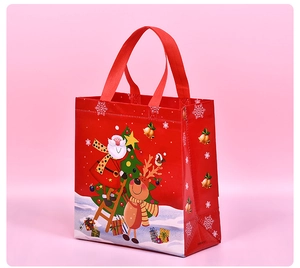 Red non-woven Christmas gift bag with cute Santa Claus and reindeer print, sturdy handles.