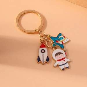 Cartoon astronaut and rocket metal keychain with star pendant on a golden ring