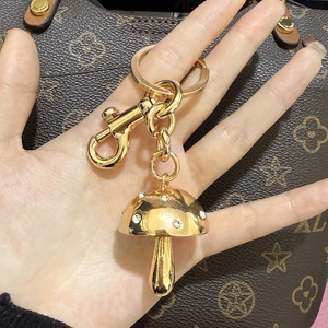 Macro-opname van een gouden paddenstoel sleutelhanger met witte strass-steentjes