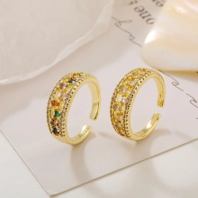 Detail of adjustable gold rings with emerald green and clear zircon in macro view