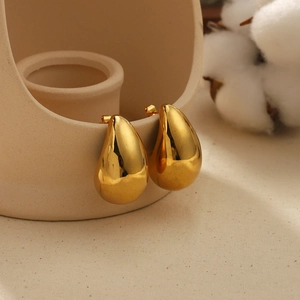 Boucles d'oreilles gouttes dorées en acier inoxydable sur bord en céramique