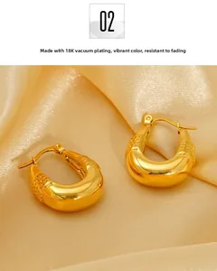 Detail of 18K gold plated U-shaped earrings with textured finish on champagne satin
