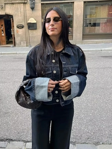 Détail d'une veste en jean bleu marine avec revers de manches larges et boutons en métal