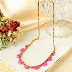 Golden stainless steel chain necklace with pink beaded crescent moon pendants on tray