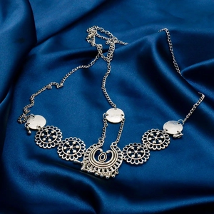 Detailed view of bohemian silver metal headpiece with hollow flowers on blue satin