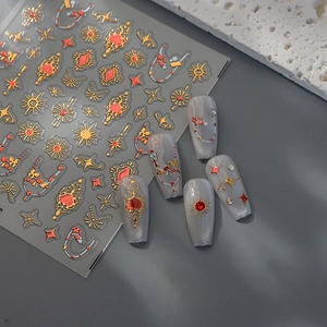 Macro detail of retro gold and red nail art stickers with celestial sun and heart patterns