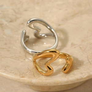 Polierte Herzringe aus 316 Edelstahl in Gold und Silber auf einem Marmortablett
