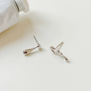 Macro shot of S925 silver stud earrings with liquid metal design and mirror finish
