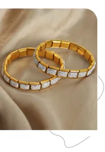 Dettaglio macro di braccialetti in acciaio al titanio dorato con pavé di zirconi lucidi
