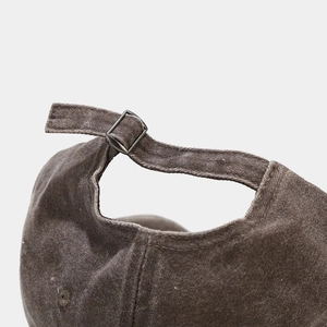 Detail of adjustable metal buckle on vintage washed baseball cap with canvas texture