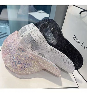 Detail of pink, white, and black sequined mesh hats with shimmering texture