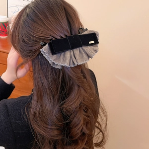 Détail de la pince à cheveux avec nœud en velours et dentelle en mousseline sur demi-queue