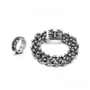 Detail of stainless steel skull ring and bracelet set with vintage punk finish