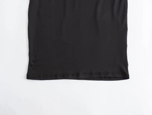 Detail of double-needle stitched hem on a black nylon asymmetric maxi dress