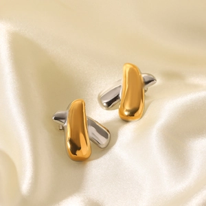 Two-tone X-shaped stainless steel stud earrings in gold and silver on silk background