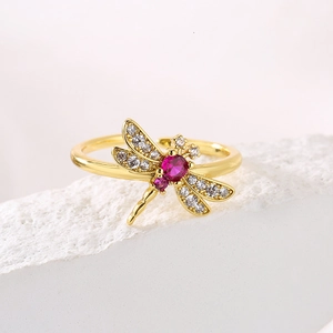 Detailed macro view of dragonfly ring with red zirconia and gold plated wing texture