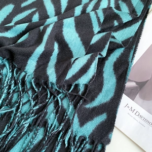 Detail shot of soft teal and black zebra stripe scarf with long fringe textures