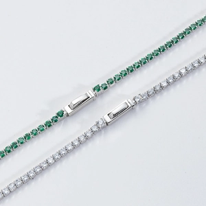 Close-up of silver tennis necklace featuring green and clear zircon stones with clasp