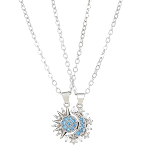 Detail of sun and moon magnetic necklaces with blue crystals on silver cross chain