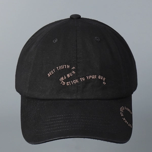Close-up of black cotton baseball cap with khaki embroidered text on the crown and brim